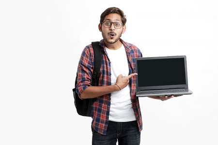 Indian college student showing laptop screen on white background.の写真素材