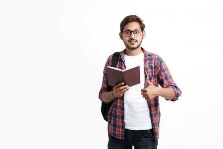 Education concept : Indian college student holding bag and showing note book on white background.の写真素材