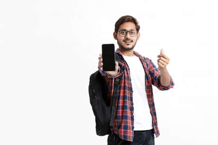 Young indian college student showing smartphone screen on white background.の写真素材