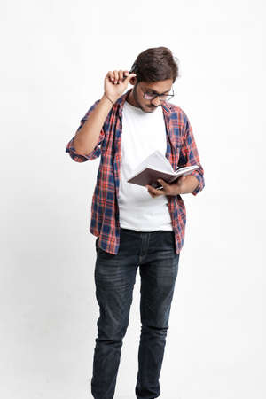 Young handsome indian college student giving thinking expression on white backgroundの写真素材