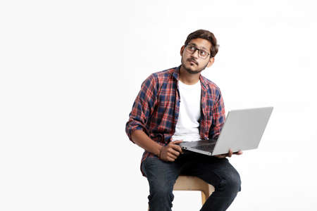 Young indian man thinking some idea when working on laptop.の写真素材