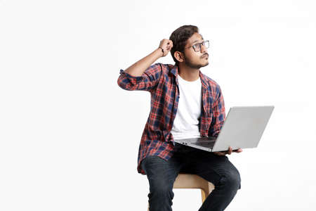 Young indian man thinking some idea when working on laptop.の写真素材