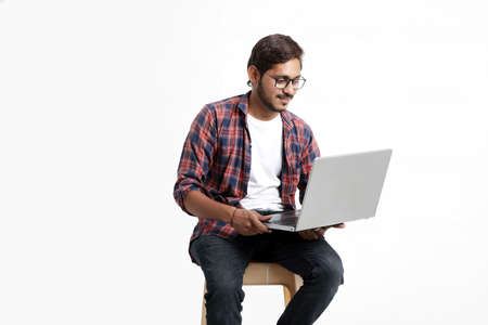Indian college student using laptop on white background.の写真素材