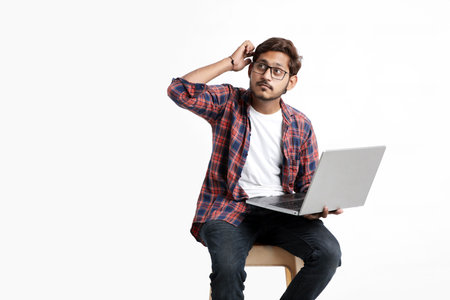 Young indian man thinking some idea when working on laptop.の写真素材