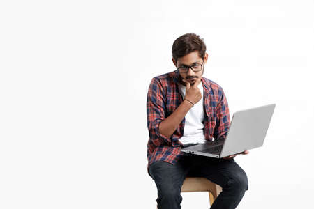 Young indian man thinking some idea when working on laptop.の写真素材