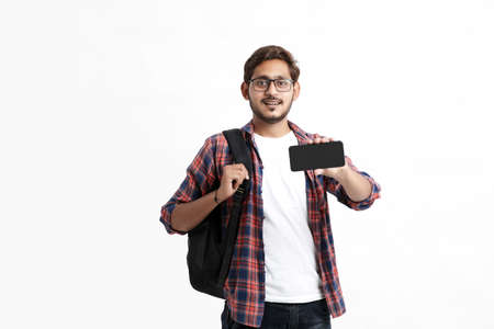 Young indian college student showing smartphone screen on white background.の写真素材