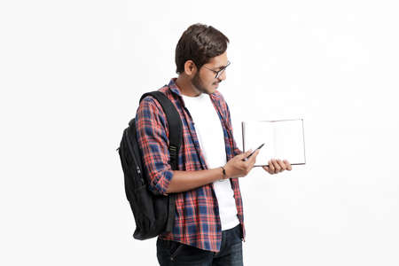 Education concept : Indian college student holding bag and showing note book on white background.の写真素材