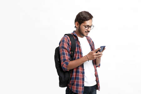 Indian college student using smartphone on white background.の写真素材