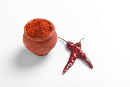 Red chilli powder with dried red chillies. in earthen bowl.の写真素材