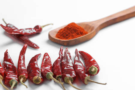 Chilli powder in wooden spoon with dry red chilly on white background.の写真素材