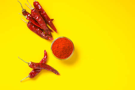 Dry Red chilli with chilli powder in glass bowl on yellow background.の写真素材