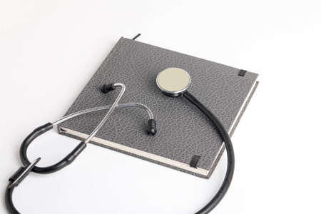 Black stethoscope lying on the diary, medicine.の写真素材