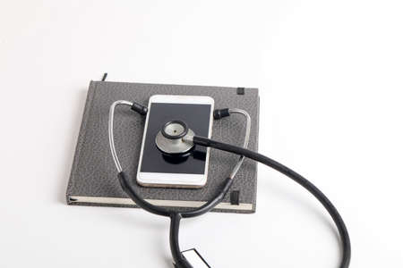 Smartphone and stethoscope on whiteの写真素材