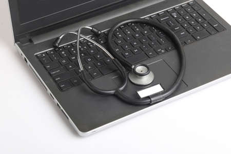 Workplace of doctor with laptop and stethoscope and smartphone on white table top view shot.の写真素材