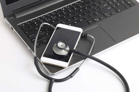 Workplace of doctor with laptop and stethoscope and smartphone on white table top view shot.の写真素材
