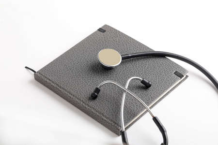 Black stethoscope lying on the diary, medicine.の写真素材