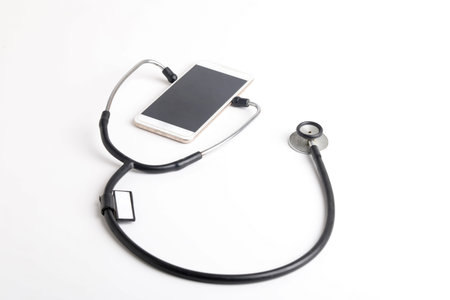 Smartphone and stethoscope on white