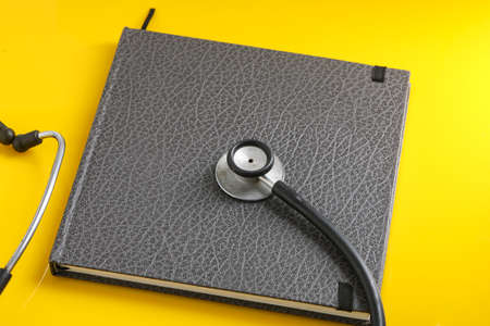 Black stethoscope lying on the diary, medicine.の写真素材
