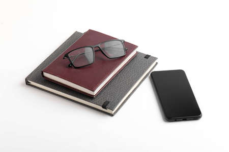 Smartphone, diary, and spectacle on whiteの写真素材