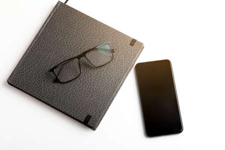 Smartphone, diary and spectacles on whiteの写真素材