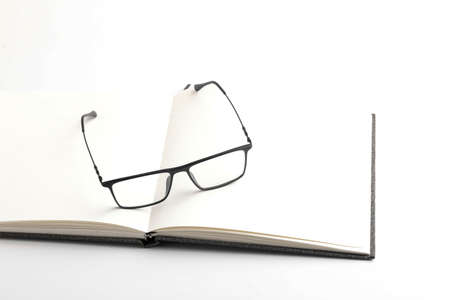 Spectacles or eyeglasses and diary on whiteの写真素材