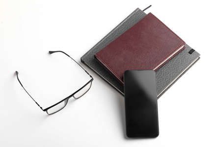 Smartphone, diary and spectacles on whiteの写真素材
