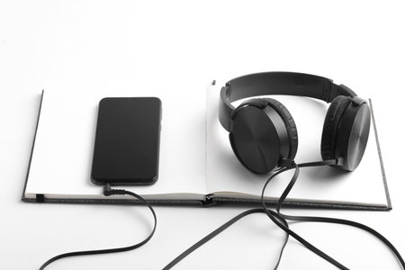 Work from home concept. Smartphone, diary and earphone on whiteの写真素材