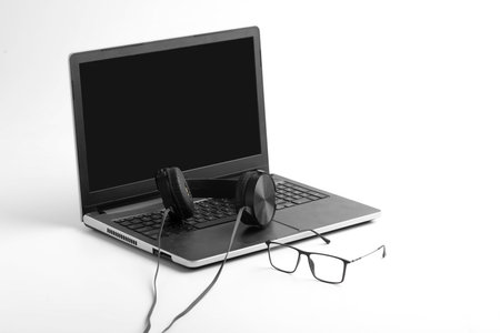Work from home concept. Laptop and earphone on whiteの写真素材