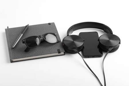 Work from home concept. smartphone, diary and earphone on whiteの写真素材