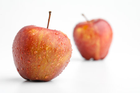 Fresh red apple with water drops isolated on whiteの写真素材