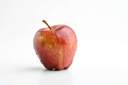 Fresh red apple with water drops isolated on whiteの写真素材