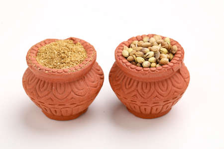 coriander seed and powder in clay bowl on white background.の写真素材