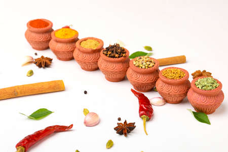 Indian spices collection, dried colorful condiment, nuts, pods and seeds and another spices in clay bowls.の写真素材
