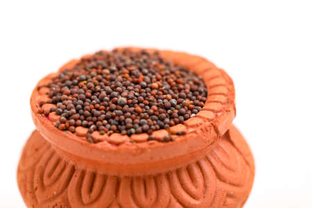 mustard seed in clay bowl on white background.の写真素材