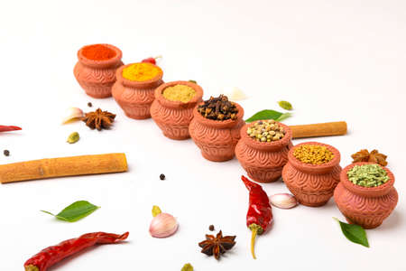 Indian spices collection, dried colorful condiment, nuts, pods and seeds and another spices in clay bowls.の写真素材