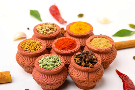 Indian spices collection, dried colorful condiment, nuts, pods and seeds and another spices in clay bowls.の写真素材