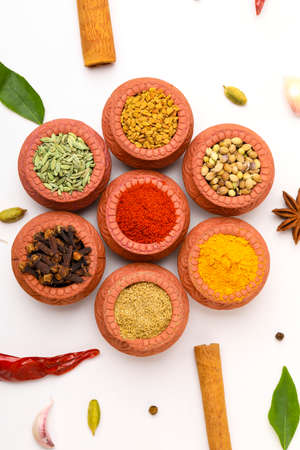 Indian spices collection, dried colorful condiment, nuts, pods and seeds and another spices in clay bowls.の写真素材