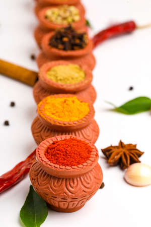 Indian spices collection, dried colorful condiment, nuts, pods and seeds and another spices in clay bowls.の写真素材