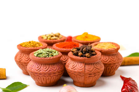 Indian spices collection, dried colorful condiment, nuts, pods and seeds and another spices in clay bowls.の写真素材