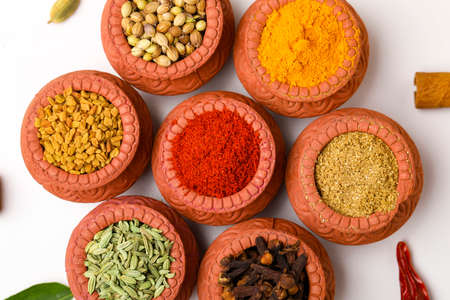Indian spices collection, dried colorful condiment, nuts, pods and seeds and another spices in clay bowls.の写真素材