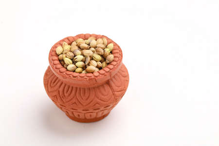 coriander seed in clay bowl on white background.の写真素材
