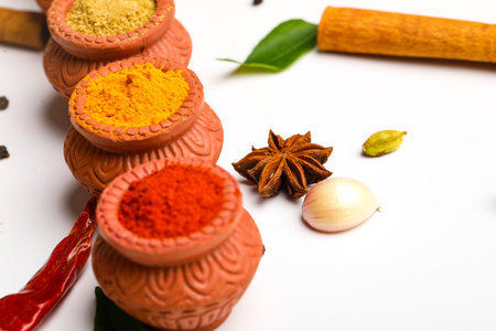 Red chilli powder,turmeric powder and coriander powder in clay bowl with other spices.の写真素材