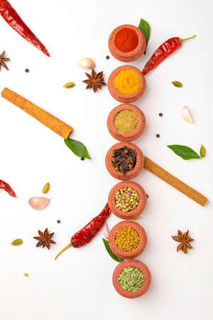 Indian spices collection, dried colorful condiment, nuts, pods and seeds and another spices in clay bowls.の写真素材