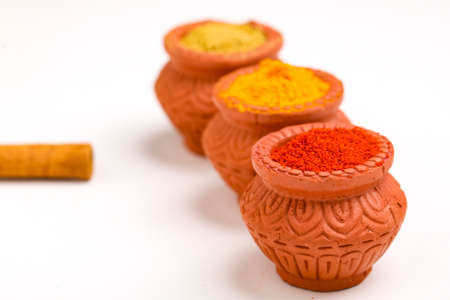 Red chilli powder,turmeric powder and coriander powder in clay bowl with other spices.の写真素材