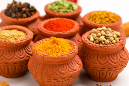 Indian spices collection, dried colorful condiment, nuts, pods and seeds and another spices in clay bowls.の写真素材