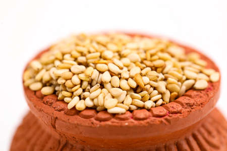 sesame seed in clay bowl over white background.の写真素材
