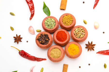 Indian spices collection, dried colorful condiment, nuts, pods and seeds and another spices in clay bowls.の写真素材