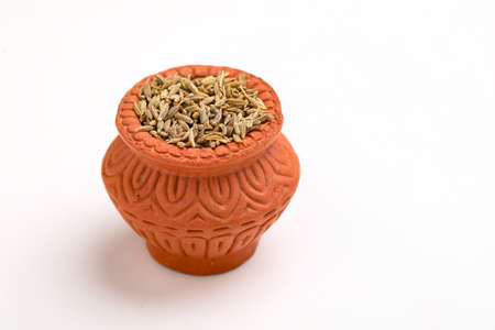 cumin seed in clay bowl on white background.の写真素材