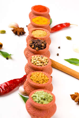 Indian spices collection, dried colorful condiment, nuts, pods and seeds and another spices in clay bowls.の写真素材