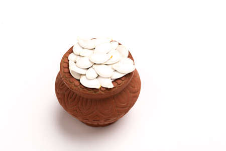 Heap of pumpkin seeds in bowl on white backgroundの写真素材